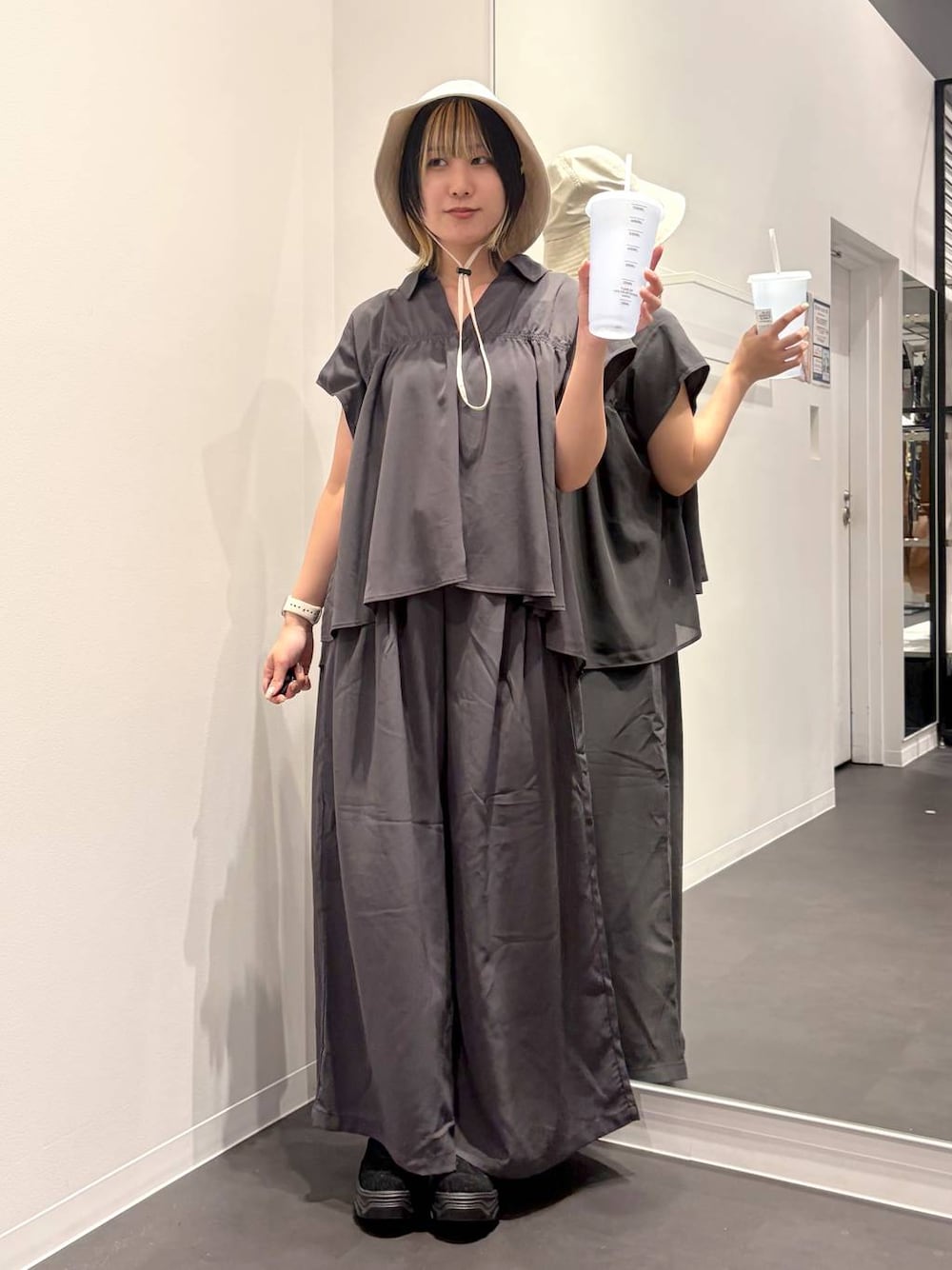 ブラック系のスニーカー、グレー系のその他パンツ、グレー系のシャツ/ブラウスを着用したレディースの夏コーディネートの1枚目の写真