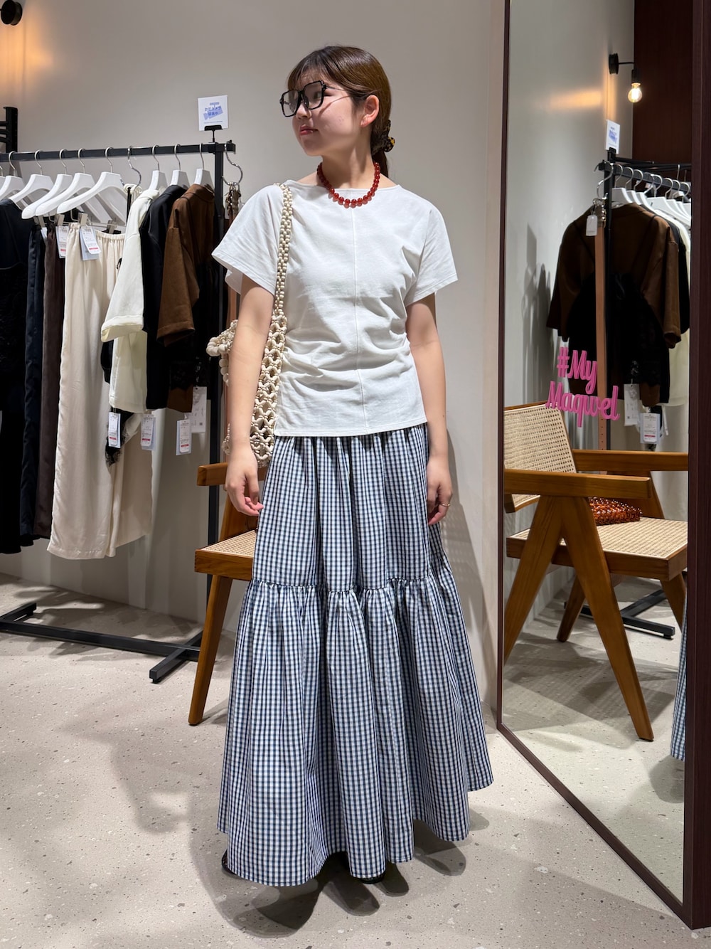 ブルー系のスカート、ホワイト系のTシャツ/カットソー、ブラック系のメガネを着用したレディースの夏コーディネートの1枚目の写真