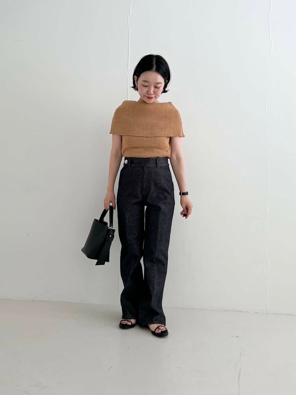 ブラック系のサンダル、ブルー系のデニムパンツ、イエロー系のニット/セーターを着用したレディースの夏コーディネートの1枚目の写真