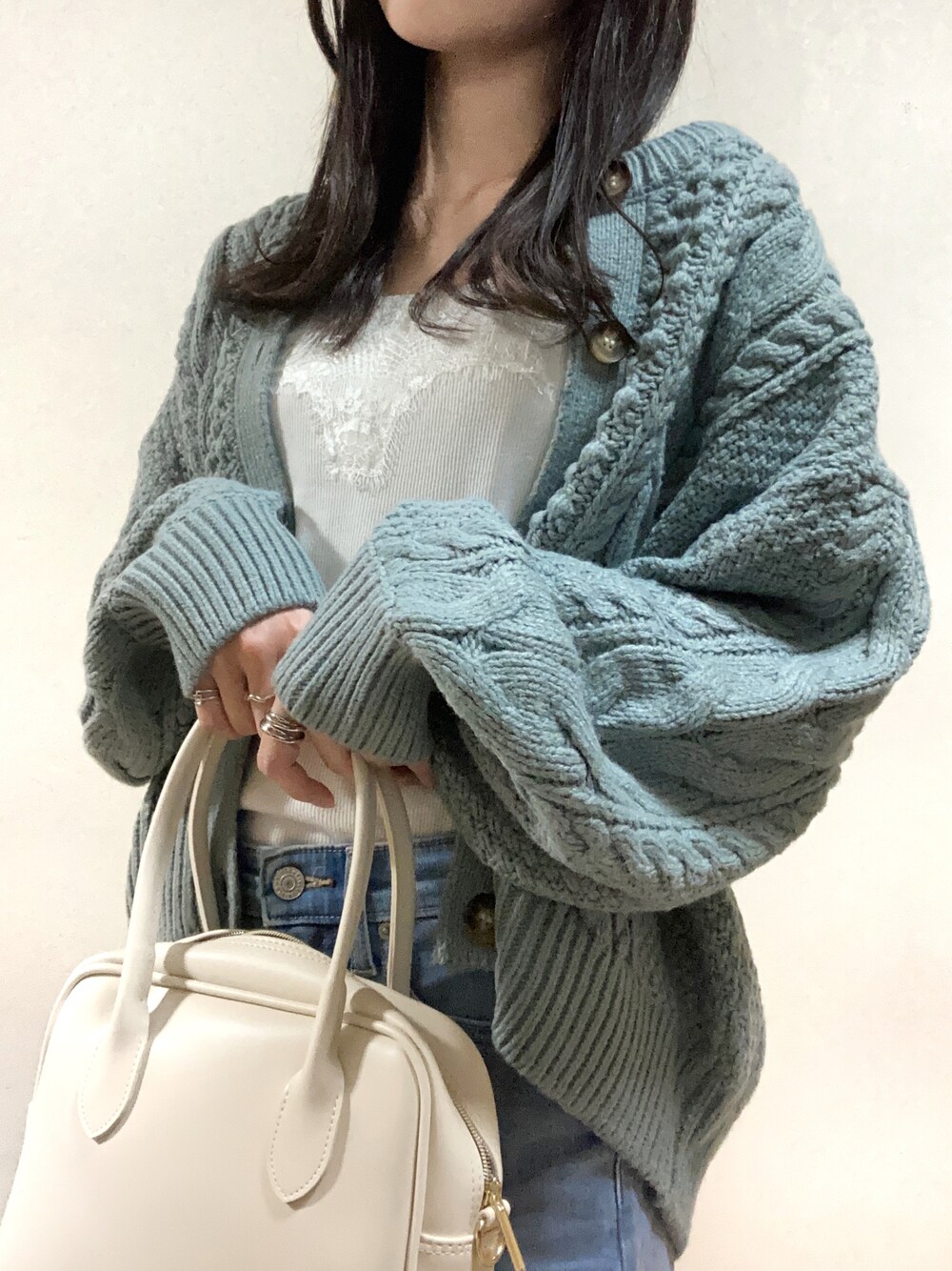ホワイト系のハンドバッグ、ブルー系のカーディガン/ボレロ、ホワイト系のタンクトップを着用したレディースの秋コーディネートの1枚目の写真