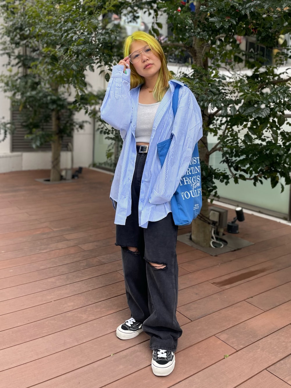 ブラック系のデニムパンツ、ブルー系のシャツ/ブラウス、ブルー系のトートバッグを着用したレディースの春コーディネートの1枚目の写真