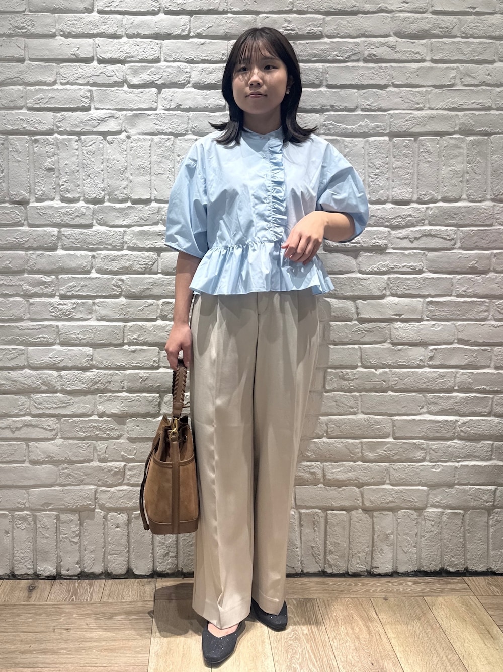 ブラック系のパンプス、ベージュ系のその他パンツ、ブラウン系のショルダーバッグを着用したレディースの春コーディネートの1枚目の写真
