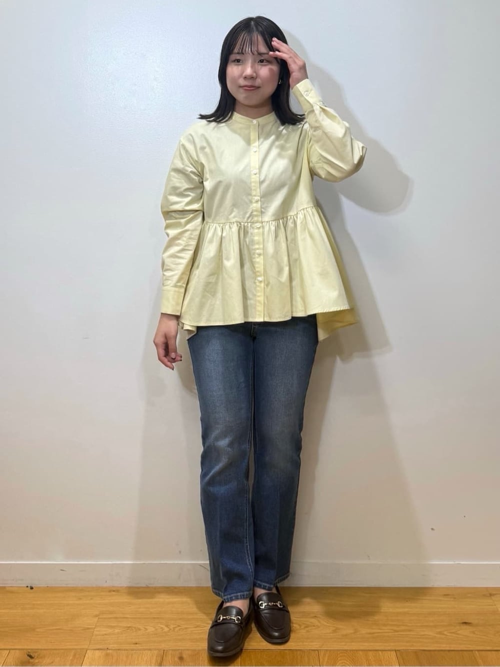 イエロー系のシャツ/ブラウス、ブルー系のデニムパンツ、ブラウン系のパンプスを着用したレディースの冬コーディネートの1枚目の写真