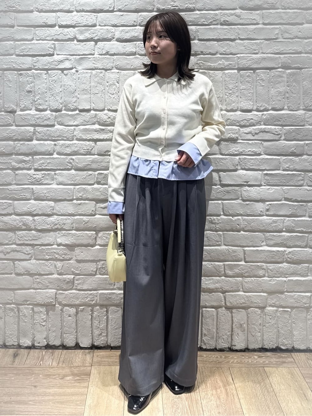 ホワイト系のカーディガン/ボレロ、グレー系のその他パンツ、イエロー系のショルダーバッグを着用したレディースの春コーディネートの1枚目の写真
