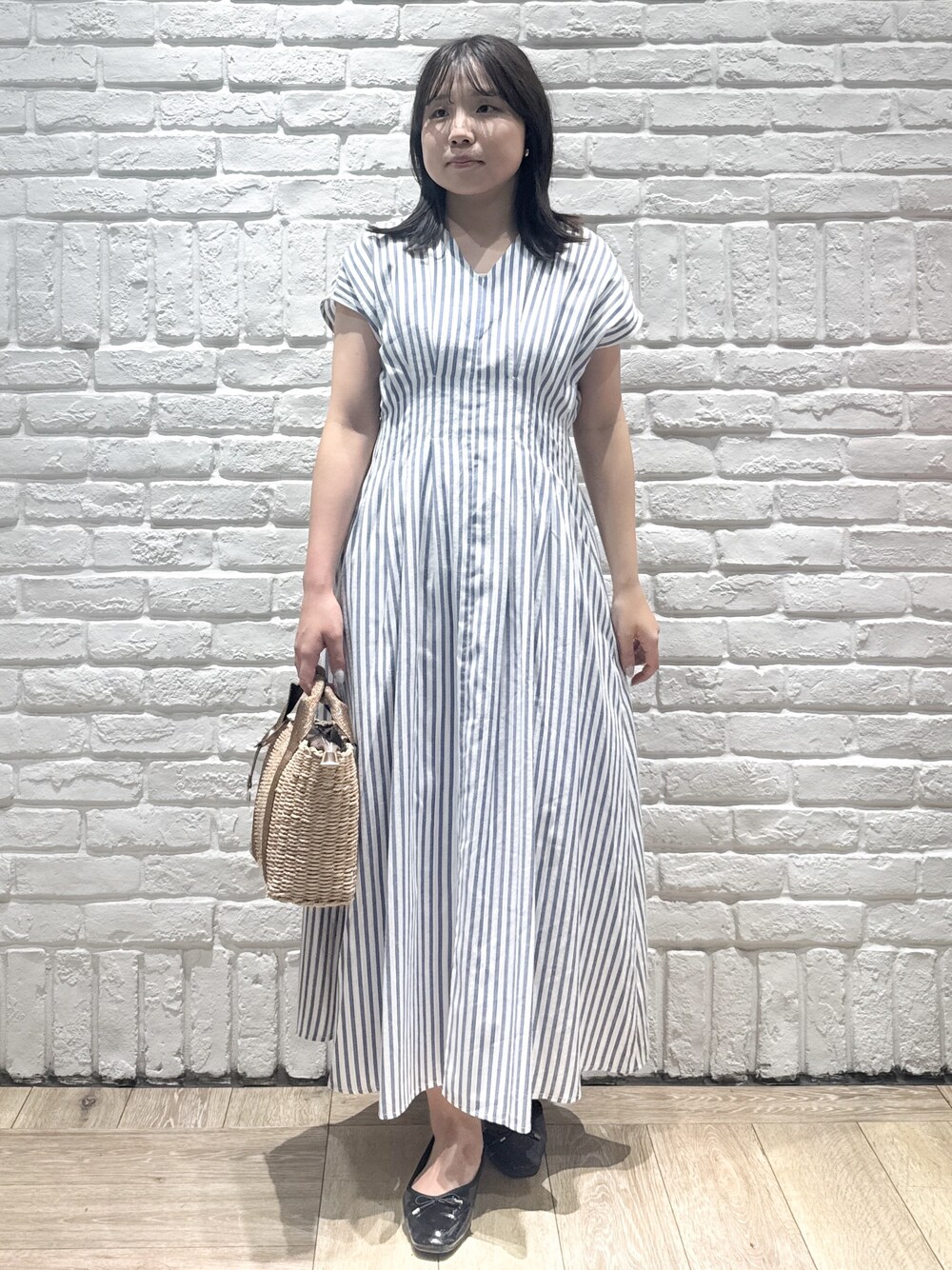 ブルー系のワンピース、ブラウン系のトートバッグ、ブラック系のパンプスを着用したレディースの夏コーディネートの1枚目の写真