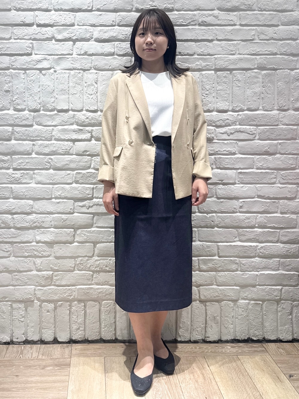 ベージュ系のテーラードジャケット、ホワイト系のTシャツ/カットソー、ブルー系のスカートを着用したレディースの春コーディネートの1枚目の写真