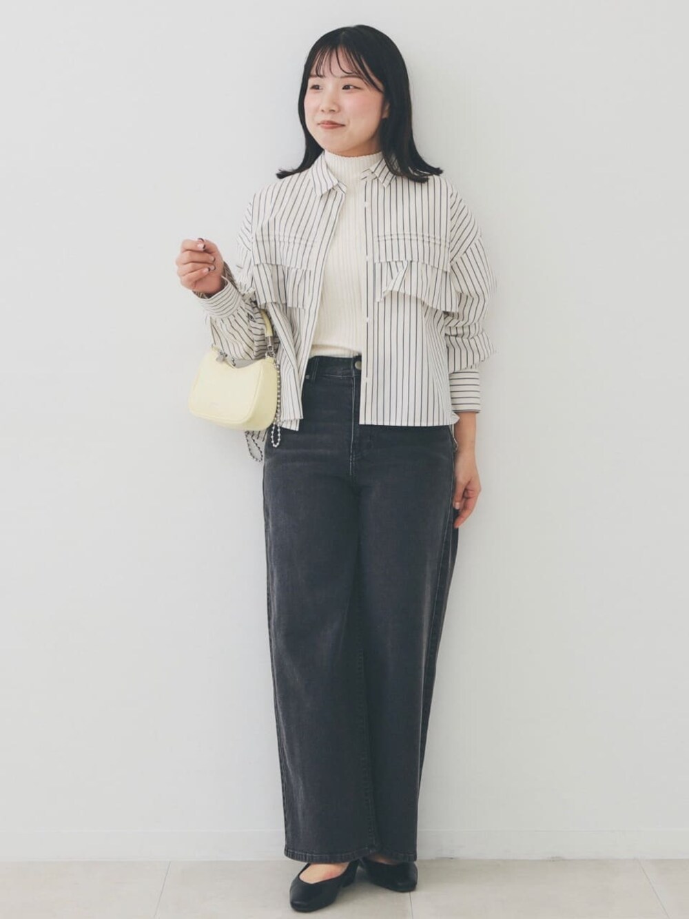 ベージュ系のシャツ/ブラウス、ホワイト系のニット/セーター、ブラック系のデニムパンツを着用したレディースの冬コーディネートの1枚目の写真
