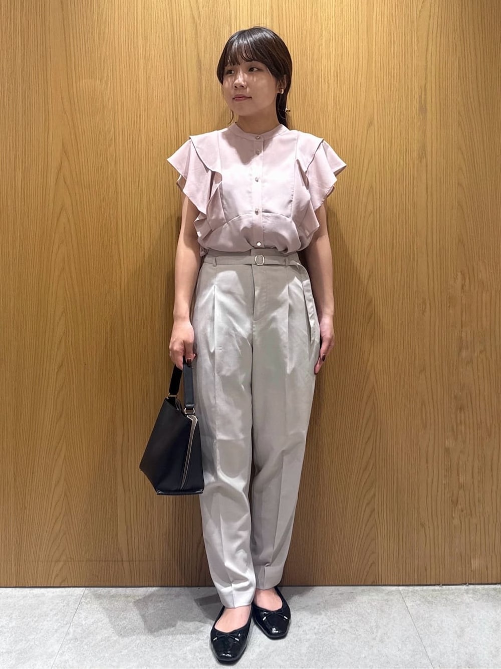 ピンク系のシャツ/ブラウス、ベージュ系のその他パンツ、ブラック系のショルダーバッグを着用したレディースの夏コーディネートの1枚目の写真