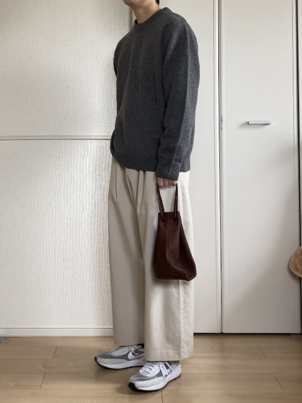 「春コーデ、ニット、モノトーン、ワイドパンツ、白パンツ、レザーバッグ、スニーカー、URBAN RESEARCH、WYM、CONFECT、NIKE、きれいめカジュアル」｜「URBAN RESEARCH ROSSOのアイテム（ニット/セーター、グレー系）」を使った、いっせいさん（メンズ・169cm）の冬コーディネートの1枚目の写真