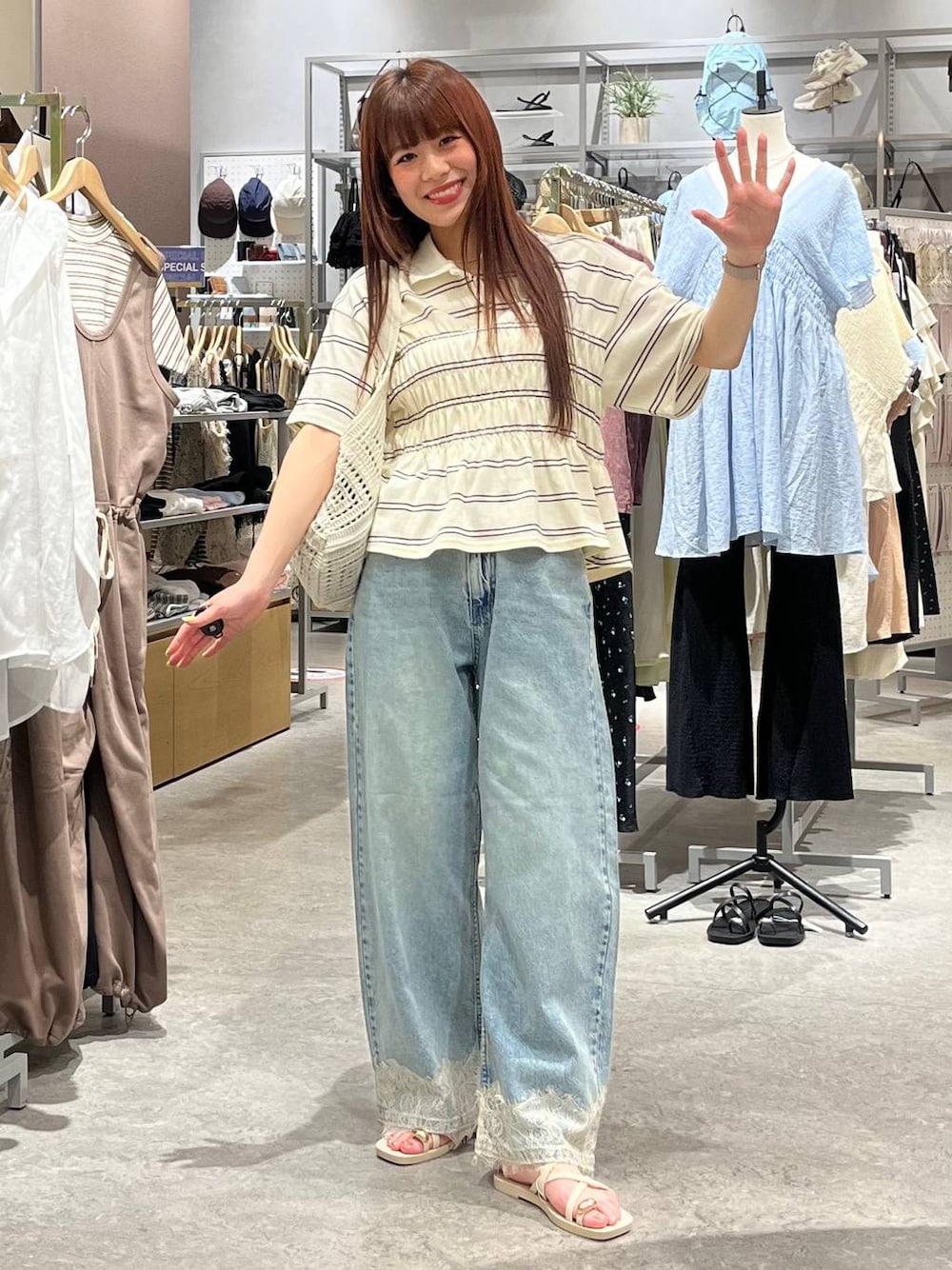 ブルー系のデニムパンツ、ホワイト系のサンダル、ホワイト系のトートバッグを着用したレディースの夏コーディネートの1枚目の写真