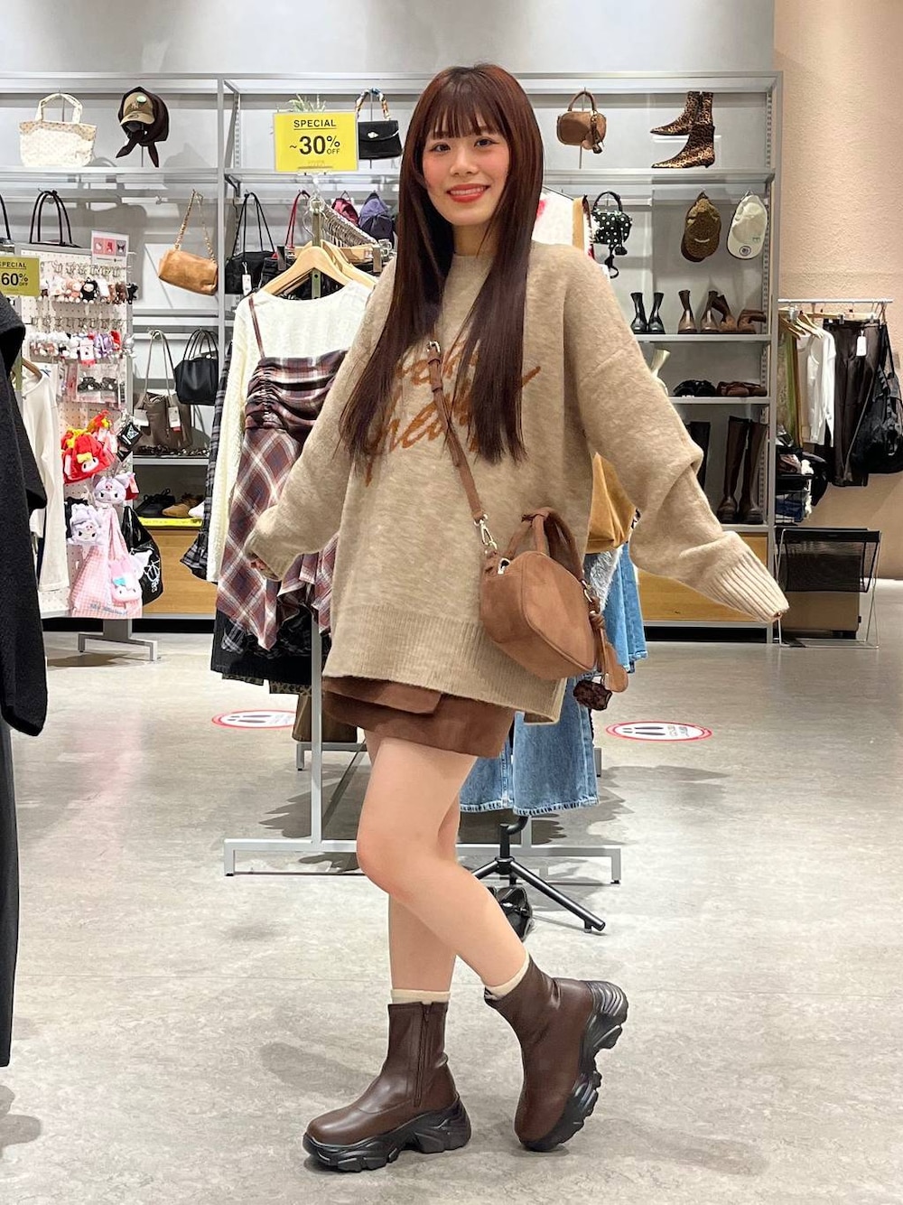 ブラウン系のブーツ、ブラウン系のスカート、ブラウン系のボストンバッグを着用したレディースの秋コーディネートの1枚目の写真