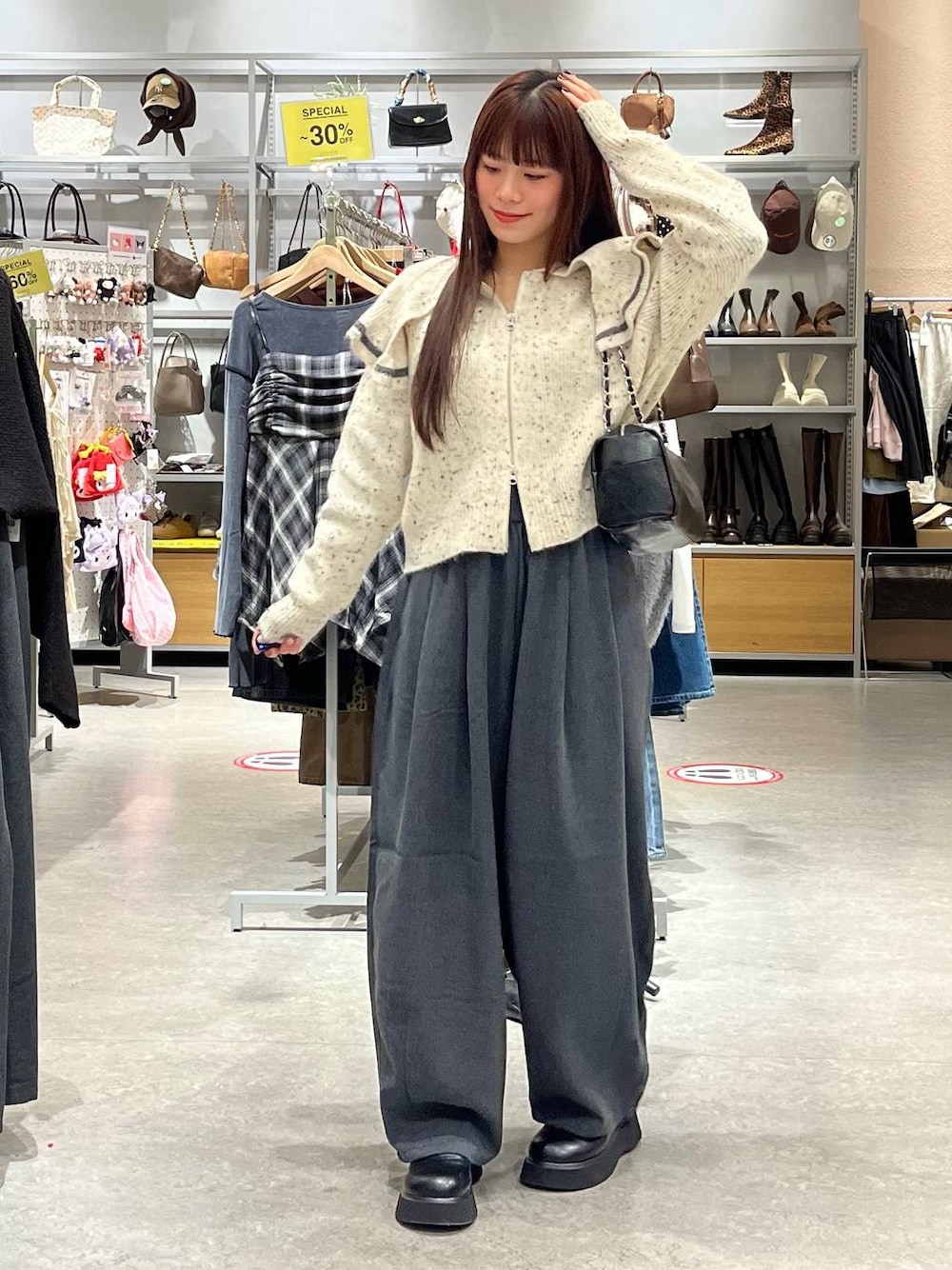 ブラック系のサンダル、ベージュ系のニット/セーター、ブラック系のショルダーバッグを着用したレディースの秋コーディネートの1枚目の写真