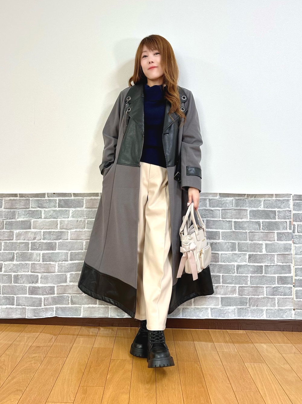 グレー系のダッフルコート、ブルー系のニット/セーター、ベージュ系のその他パンツを着用したレディースの秋コーディネートの1枚目の写真