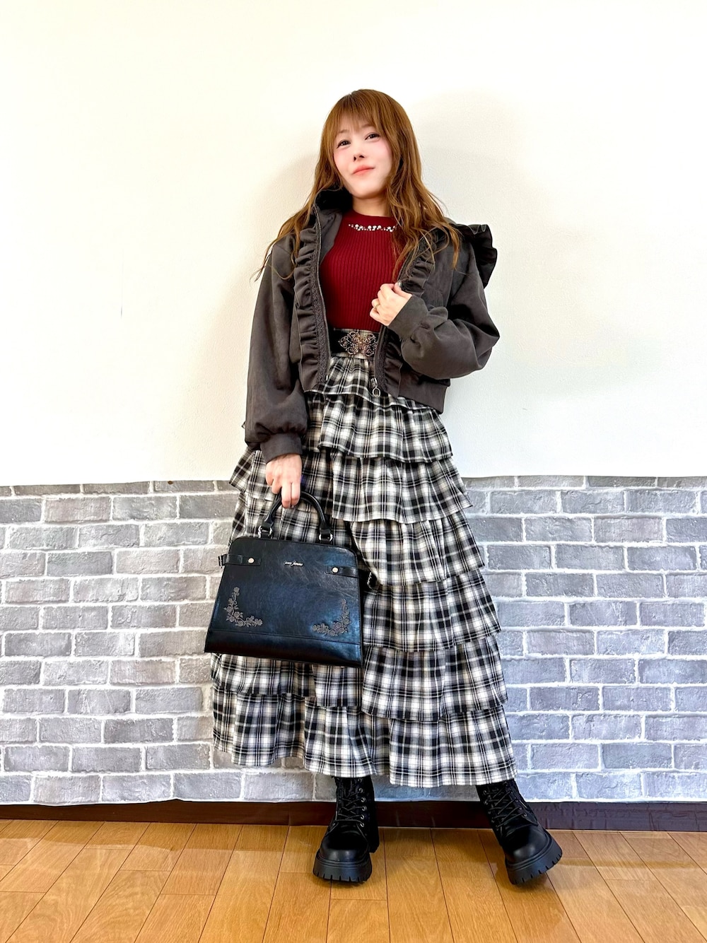 グレー系のパーカー、レッド系のニット/セーター、レッド系のスカートを着用したレディースの秋コーディネートの1枚目の写真