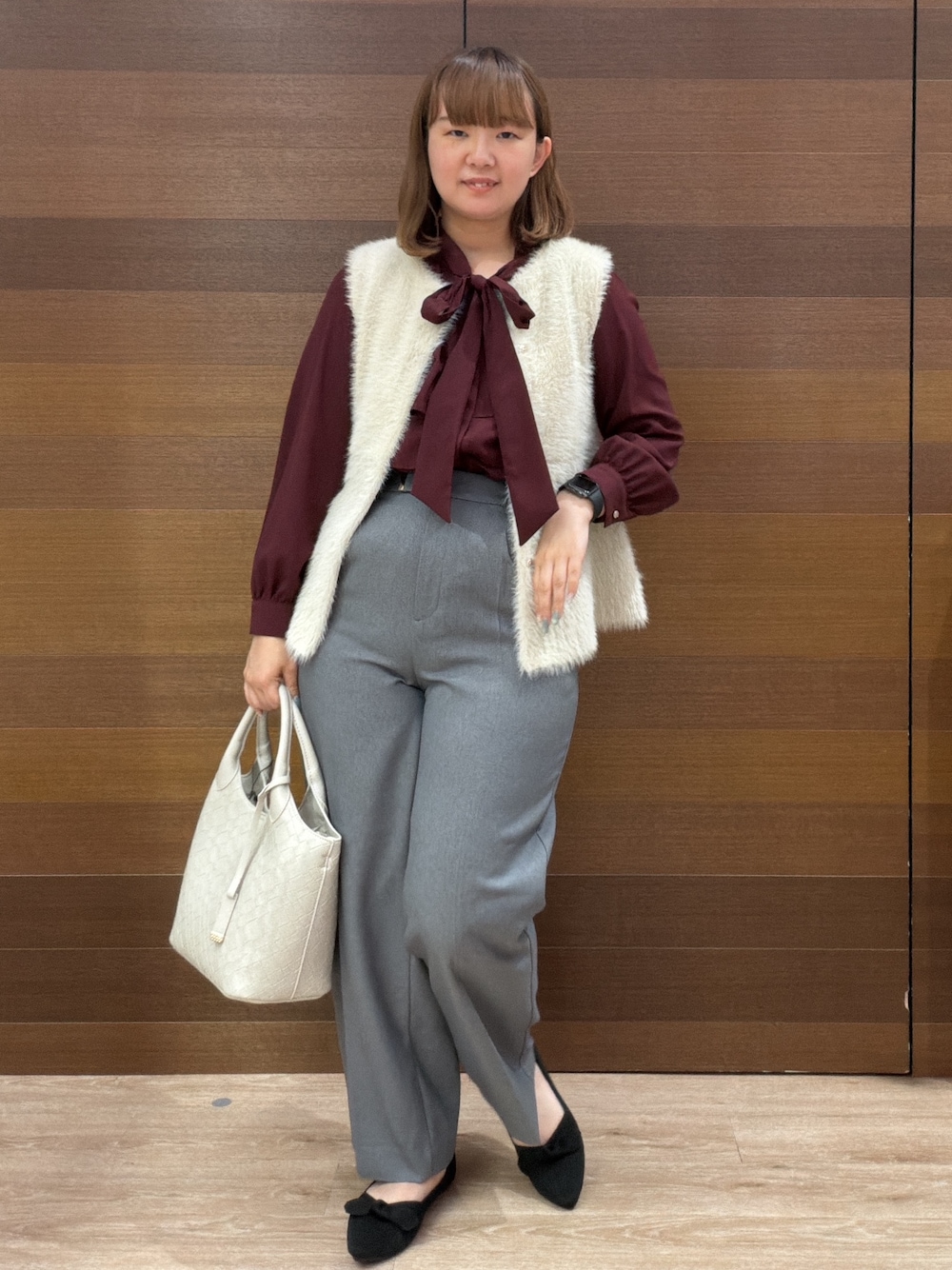 ベージュ系のベスト、レッド系のシャツ/ブラウス、グレー系のその他パンツを着用したレディースの秋コーディネートの1枚目の写真