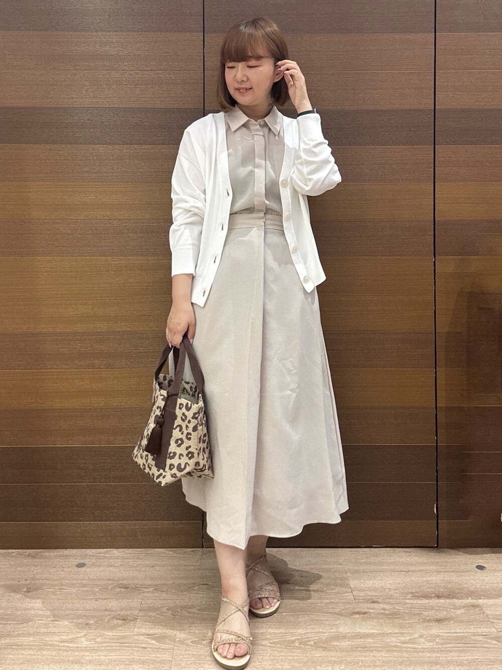 ベージュ系のワンピース、ブラウン系のトートバッグ、ゴールド系のサンダルを着用したレディースの夏コーディネートの1枚目の写真