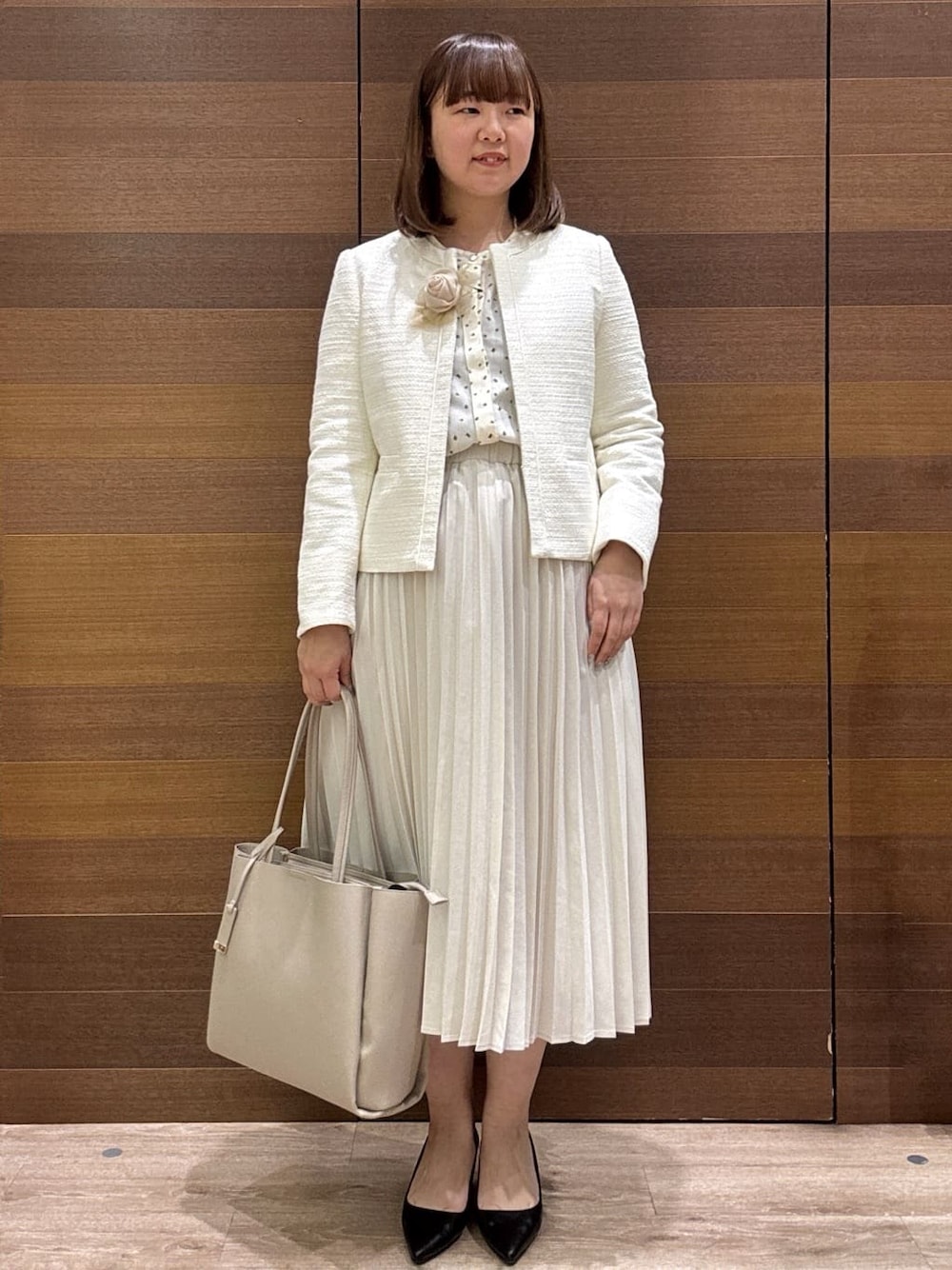 ホワイト系のノーカラージャケット、ベージュ系のシャツ/ブラウス、ベージュ系のスカートを着用したレディースの冬コーディネートの1枚目の写真
