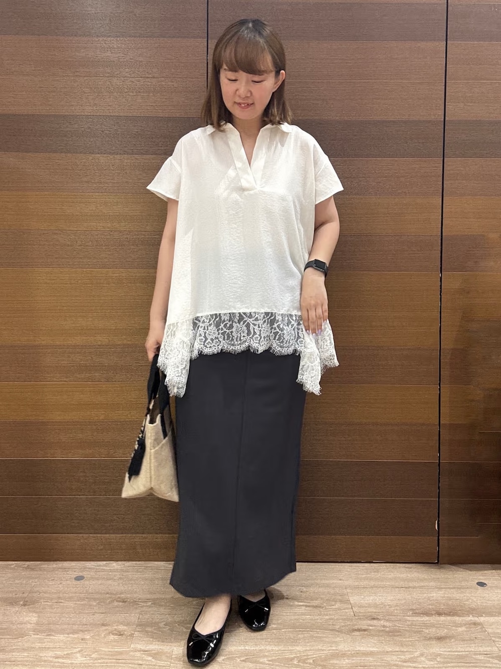 ホワイト系のシャツ/ブラウス、グレー系のスカート、ブラック系のトートバッグを着用したレディースの夏コーディネートの1枚目の写真