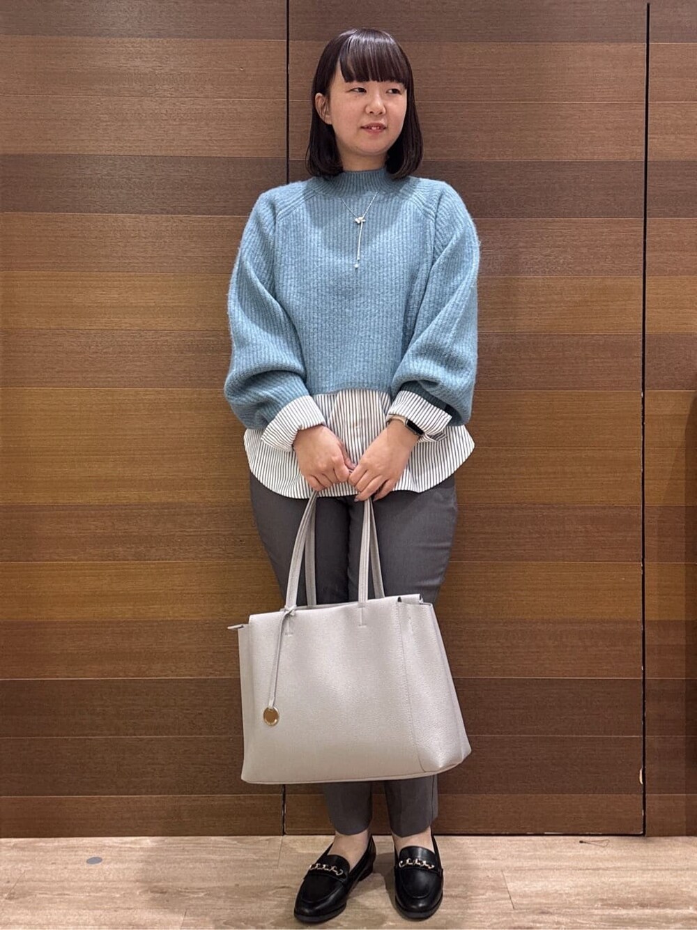 ブルー系のニット/セーター、ホワイト系のTシャツ/カットソー、グレー系のその他パンツを着用したレディースの冬コーディネートの1枚目の写真