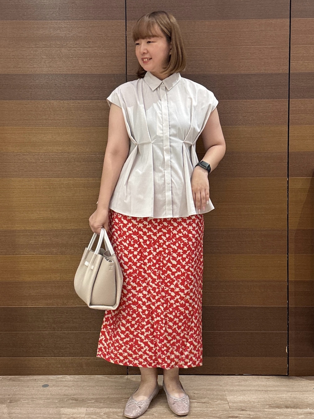 ベージュ系のシャツ/ブラウス、レッド系のスカート、ベージュ系のトートバッグを着用したレディースの夏コーディネートの1枚目の写真