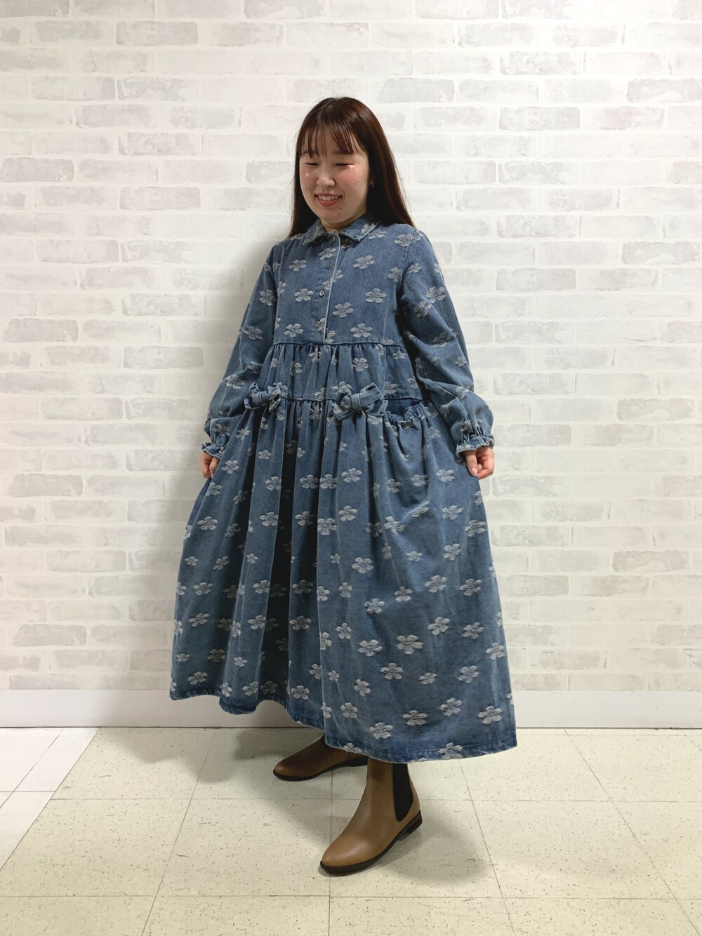 ブラウン系のブーツを着用したレディースの秋コーディネートの1枚目の写真