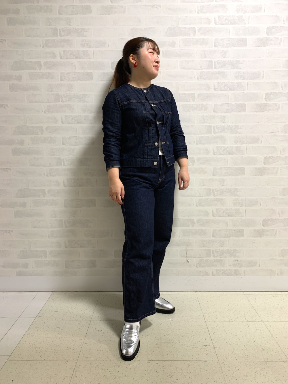 ブルー系のデニムジャケット、シルバー系のローファーを着用したレディースの秋コーディネートの1枚目の写真