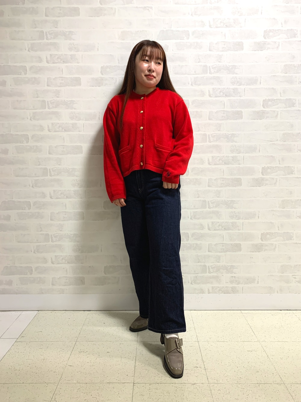 レッド系のカーディガン/ボレロ、グレー系のパンプスを着用したレディースの秋コーディネートの1枚目の写真