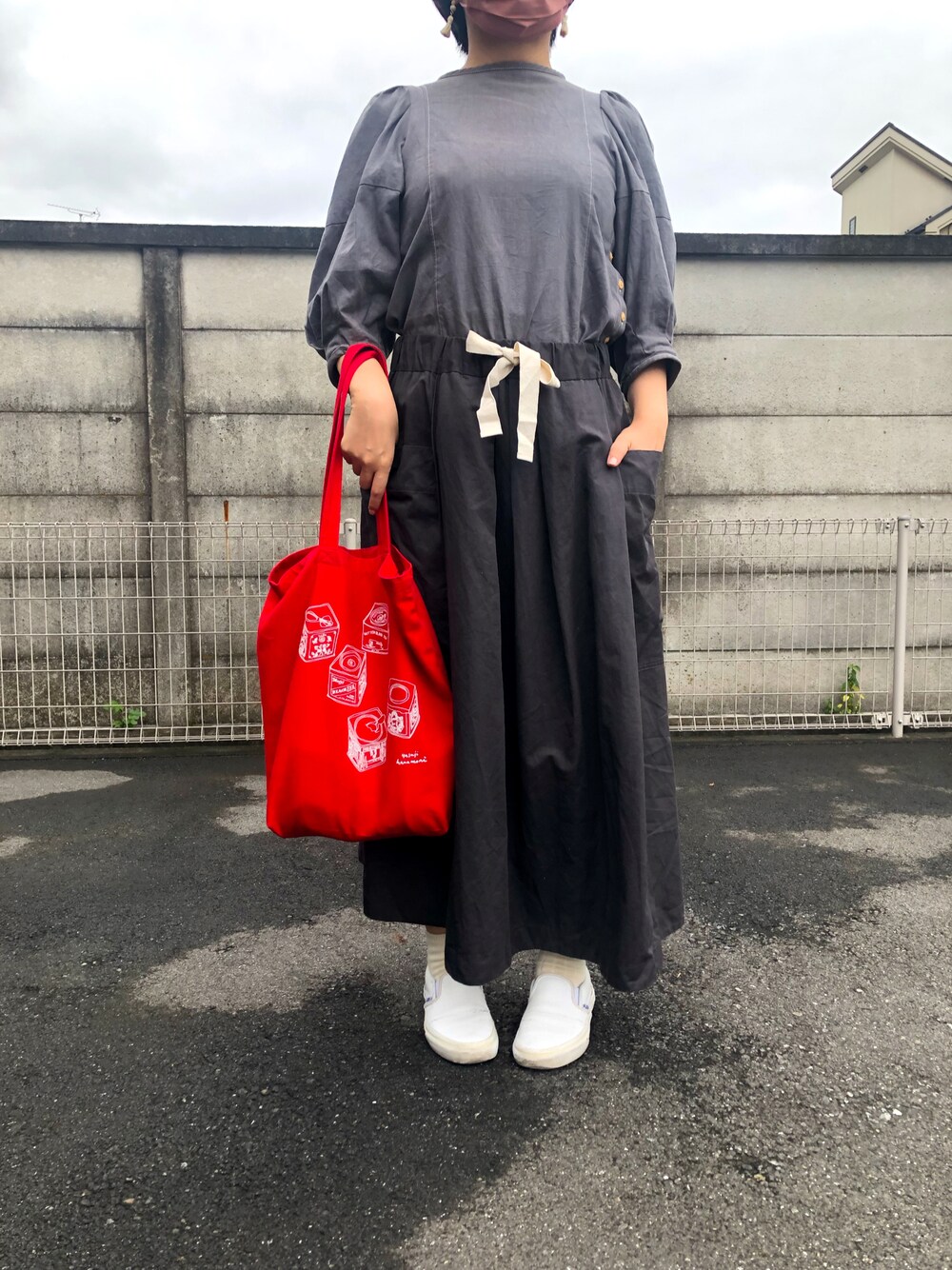 レッド系のエコバッグ/サブバッグ、ホワイト系のスリッポン、グレー系のスカートを着用したレディースの秋コーディネートの1枚目の写真