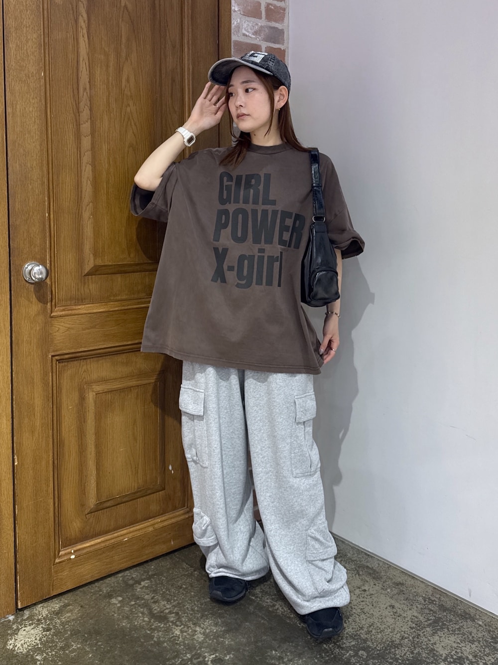 ブラウン系のワンピース、グレー系のスウェットパンツ、ブラック系のショルダーバッグを着用したレディースの夏コーディネートの1枚目の写真