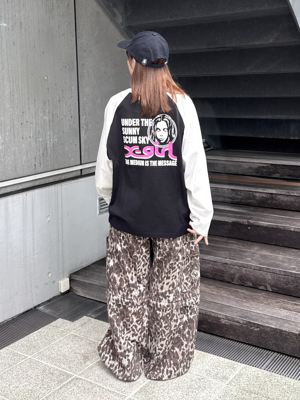 ブラック系のTシャツ/カットソー、ベージュ系のカーゴパンツ、ブラック系のキャップを着用したレディースの秋コーディネートの1枚目の写真