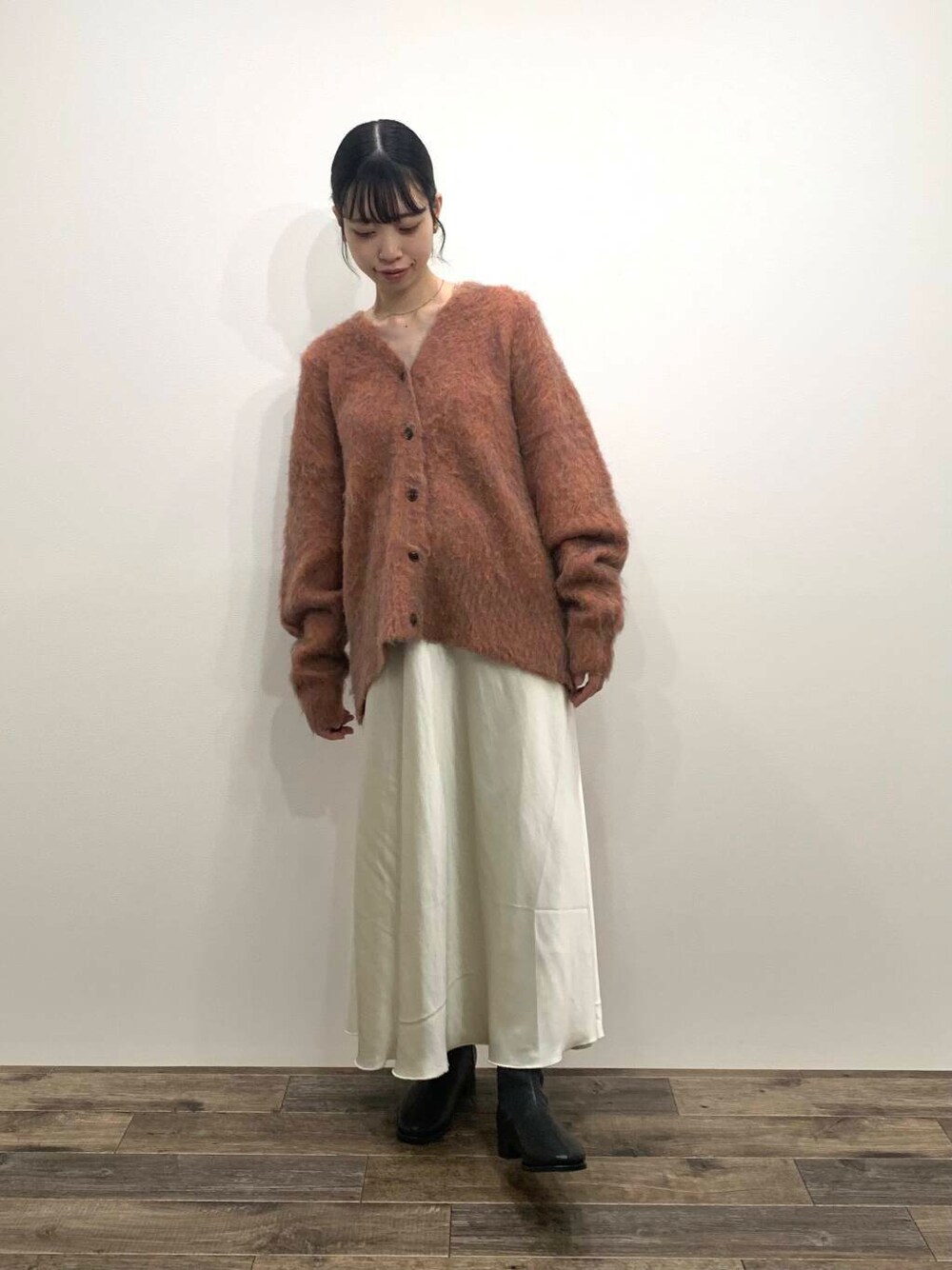 ブラック系のブーツ、ホワイト系のスカート、オレンジ系のカーディガン/ボレロを着用したレディースの秋コーディネートの1枚目の写真