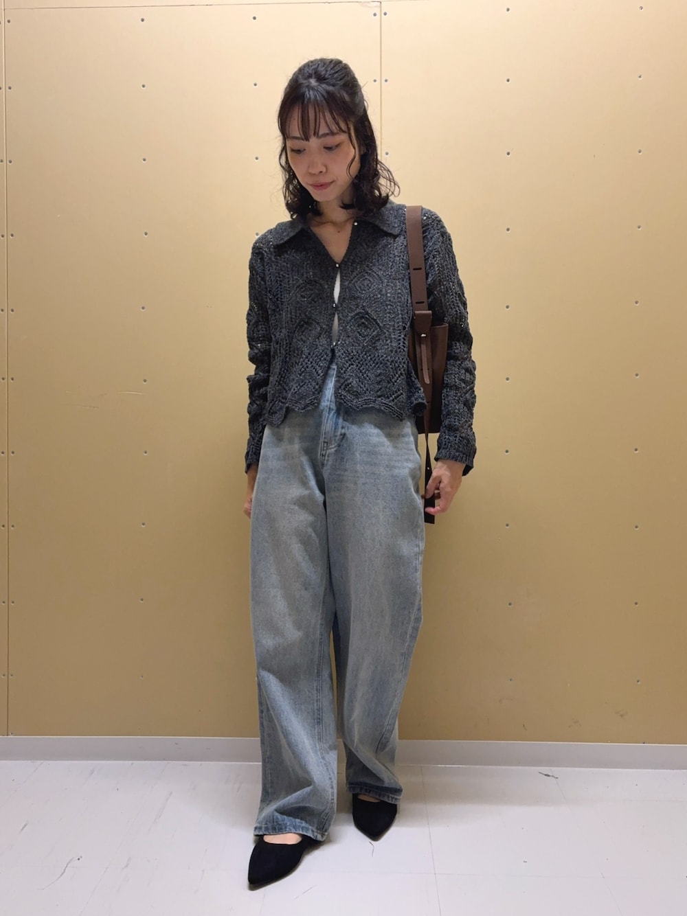 ブルー系のデニムパンツ、グレー系のカーディガン/ボレロ、ブラウン系のショルダーバッグを着用したレディースの秋コーディネートの1枚目の写真