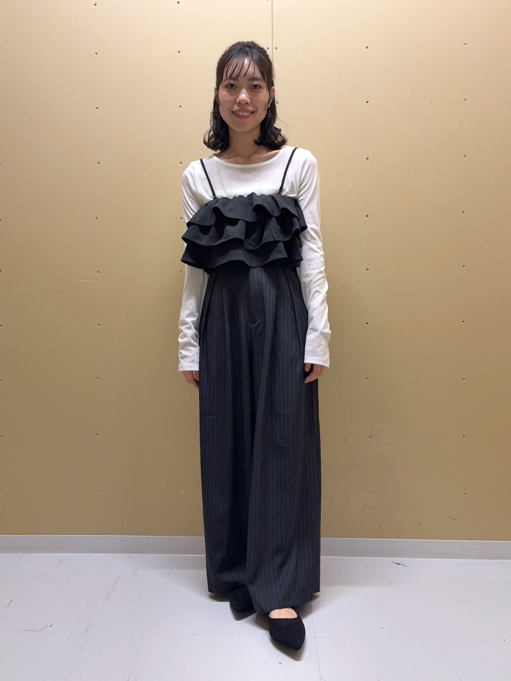 グレー系のその他パンツ、ブラック系のキャミソール、ホワイト系のTシャツ/カットソーを着用したレディースの秋コーディネートの1枚目の写真
