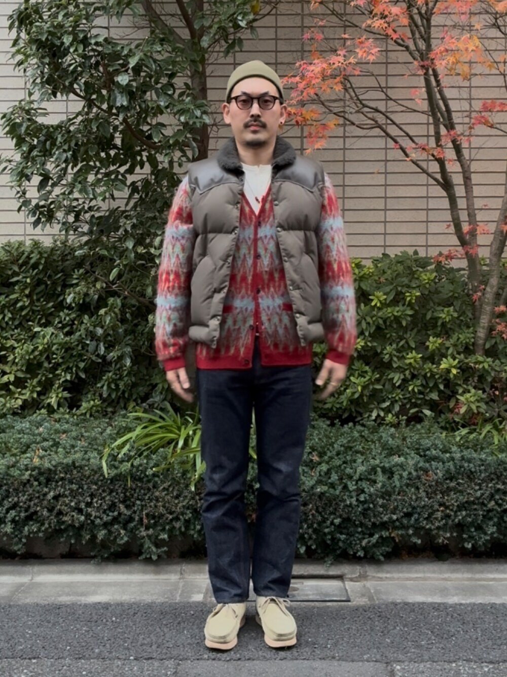 ベージュ系のモカシン/デッキシューズ、ブルー系のデニムパンツ、レッド系のカーディガン/ボレロを着用したメンズの冬コーディネートの1枚目の写真