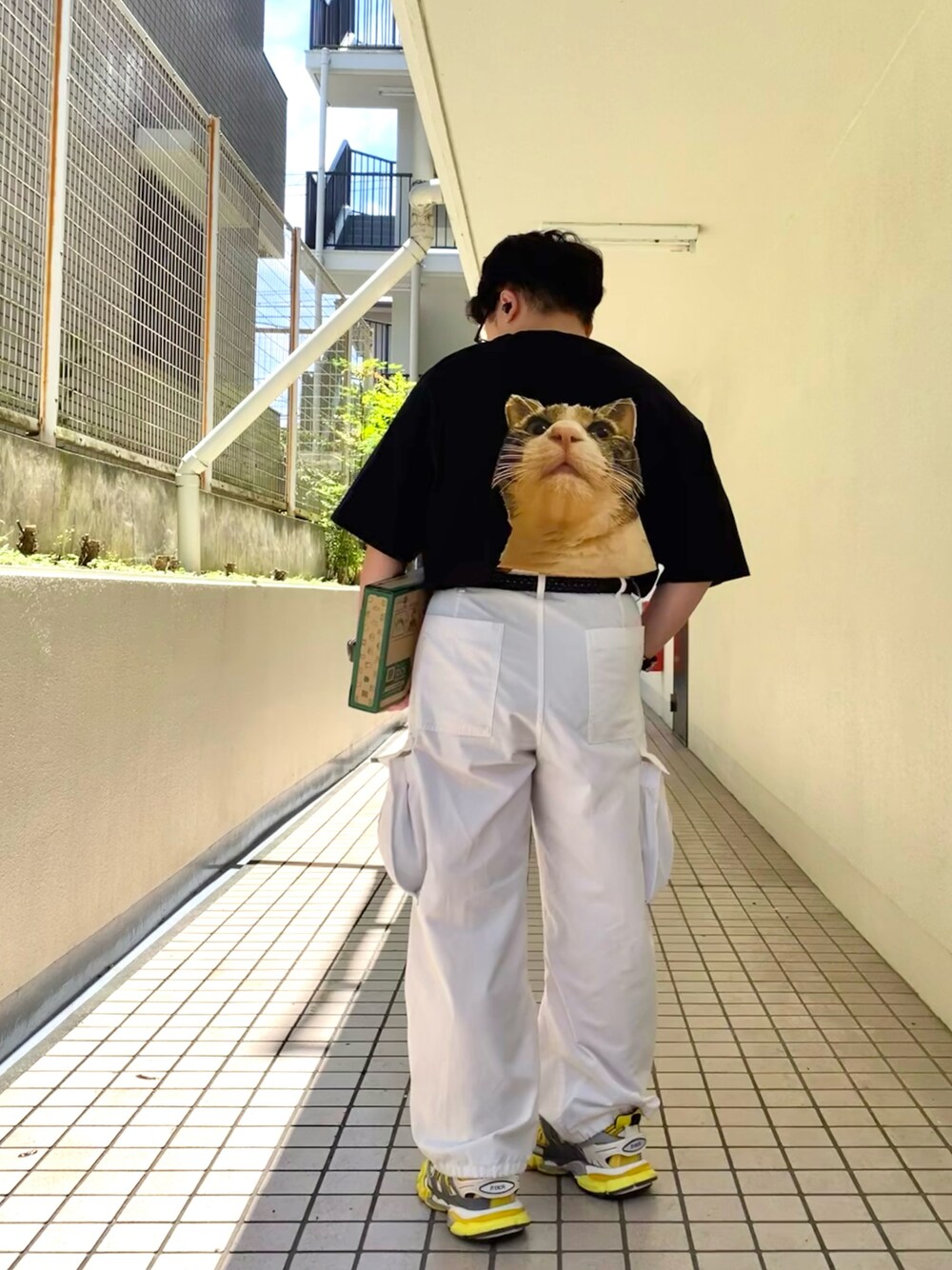 ホワイト系のカーゴパンツ、イエロー系のスニーカー、ブラック系のTシャツ/カットソーを着用したメンズの夏コーディネートの1枚目の写真
