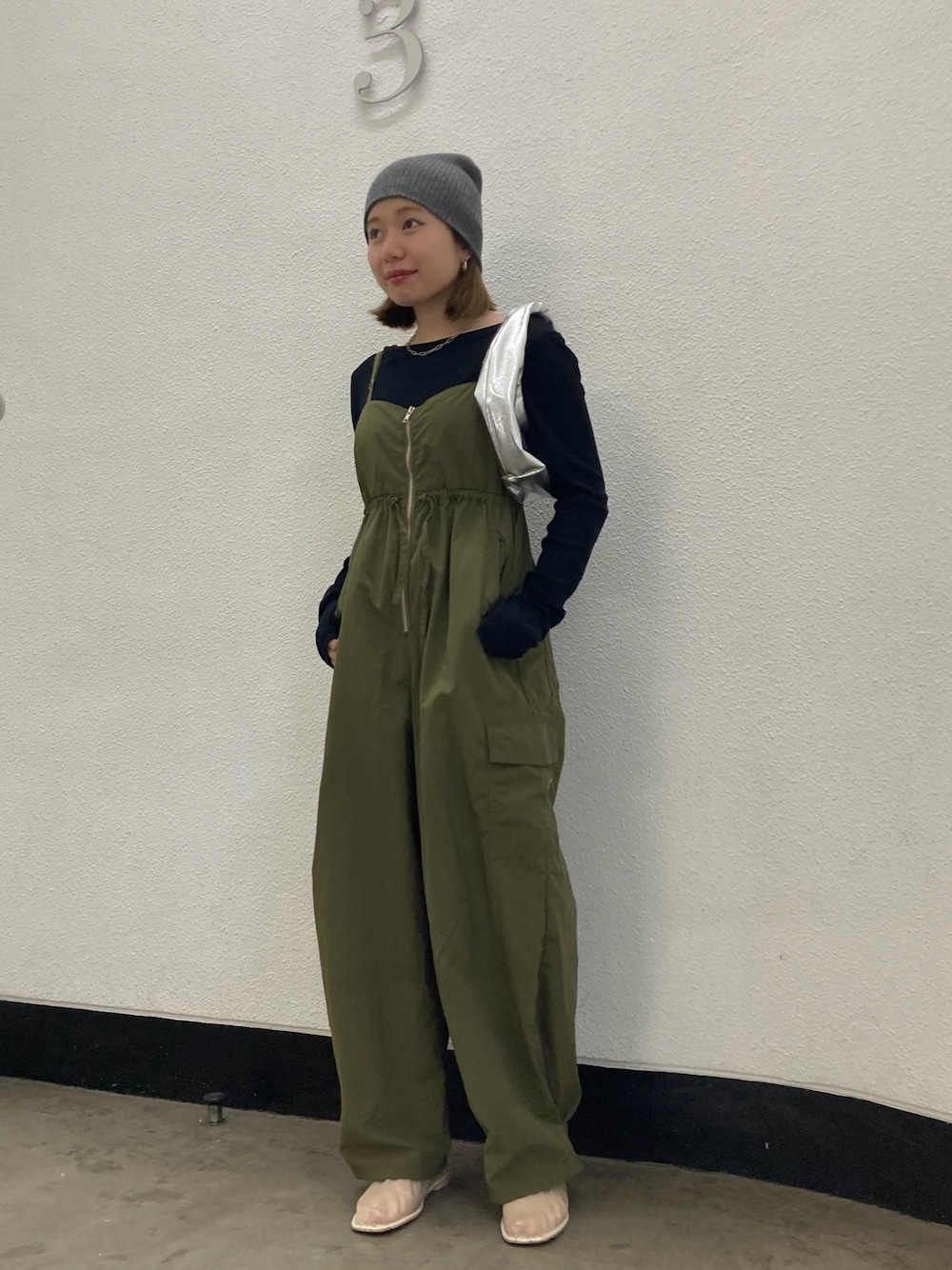グリーン系のサロペット/オーバーオール、ブラック系のTシャツ/カットソー、シルバー系のハンドバッグを着用したレディースの冬コーディネートの1枚目の写真