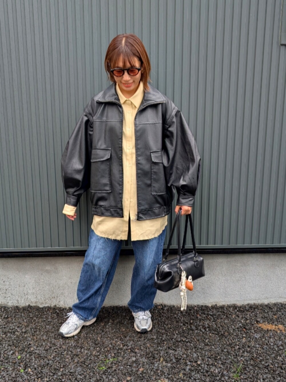 イエロー系のシャツ/ブラウス、ブラック系のライダースジャケット、ブラック系のトートバッグを着用したレディースの秋コーディネートの1枚目の写真