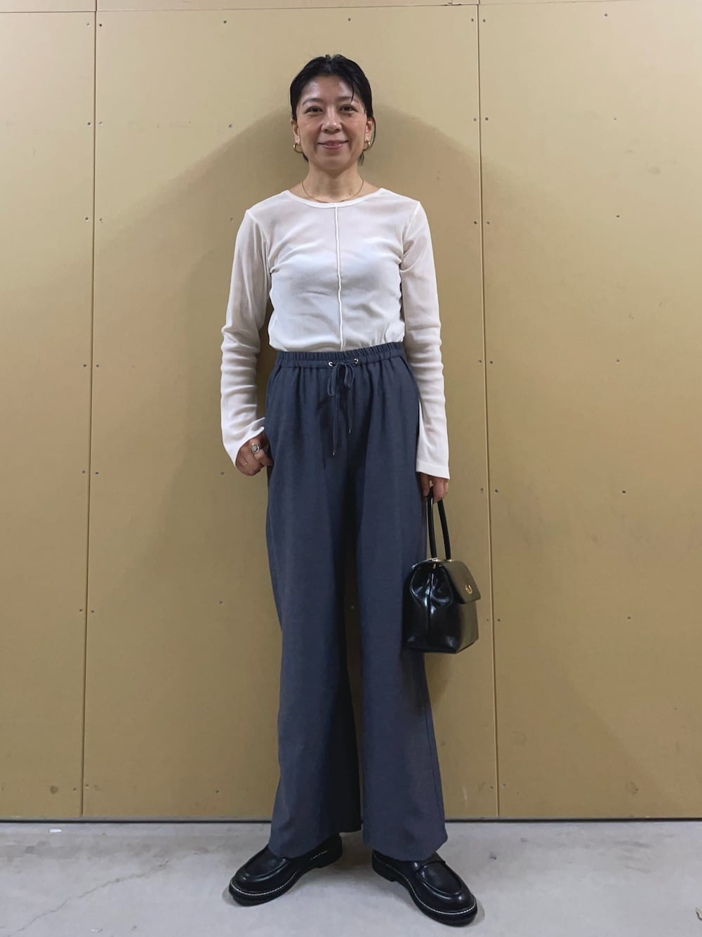 ブラック系のショルダーバッグ、ブルー系のその他パンツ、ブラック系のその他シューズを着用したレディースの春コーディネートの1枚目の写真