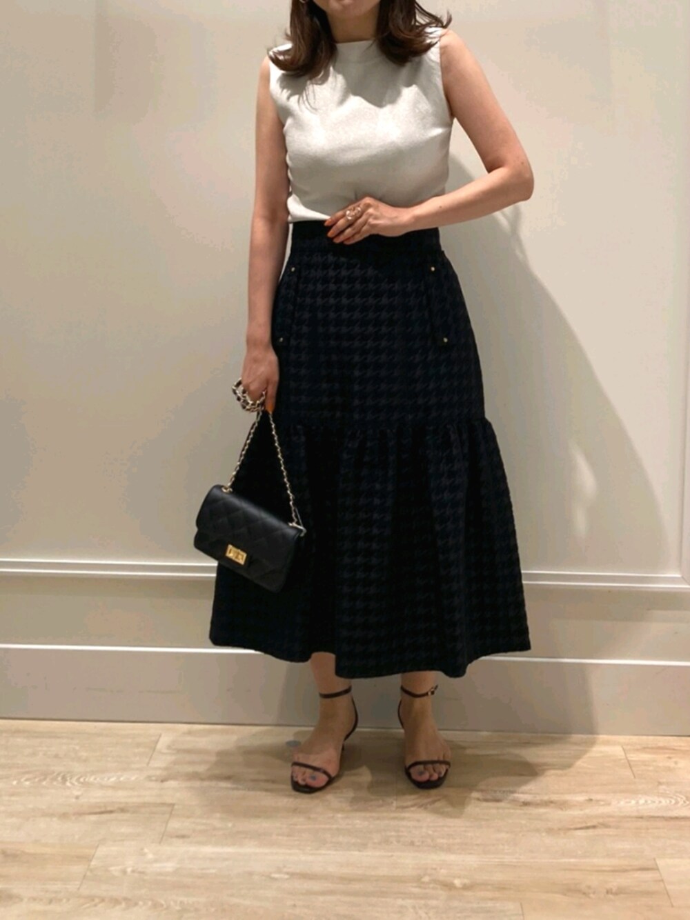 「お出かけコーデ、休日スタイル、オトナ女子、大人かわいい、シンプルスタイル、秋服、スカート、ジャガード、チドリ柄、ラメ、クラシカル、サンダル、チェーンバッグ、モノトーン、キレイめ」｜「NOLLEY’Sの《手洗い可能》ラメ総針ノースリーブプルオーバーニット（ニット/セーター、シルバー系）」を使った、nol  komatsubaraさん（レディース・159cm）の夏コーディネートの1枚目の写真