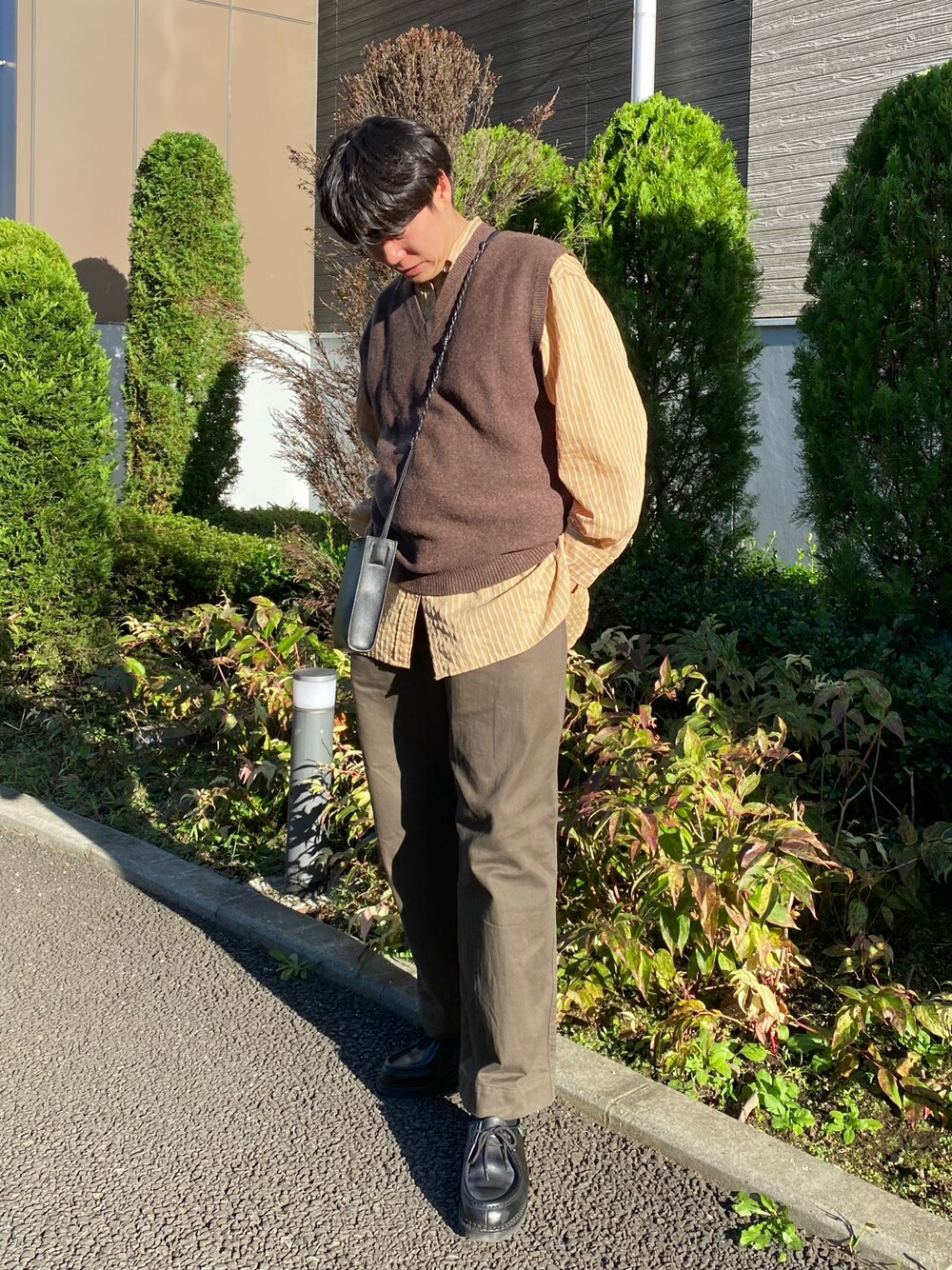 「重ね着ベストシーズン、ベスト、レイヤードスタイル、ストライプシャツ、ブラウン、プチプラ、きれいめカジュアル、ミニバッグ、ショルダーバッグ、秋コーデ、お出かけコーデ、ニット、ビッグシルエット、ゆるコーデ、UNIQLO」｜「UNIQLOのアイテム（パンツ、グリーン系）」を使った、しゅんたさん（メンズ・172cm）の秋コーディネートの1枚目の写真