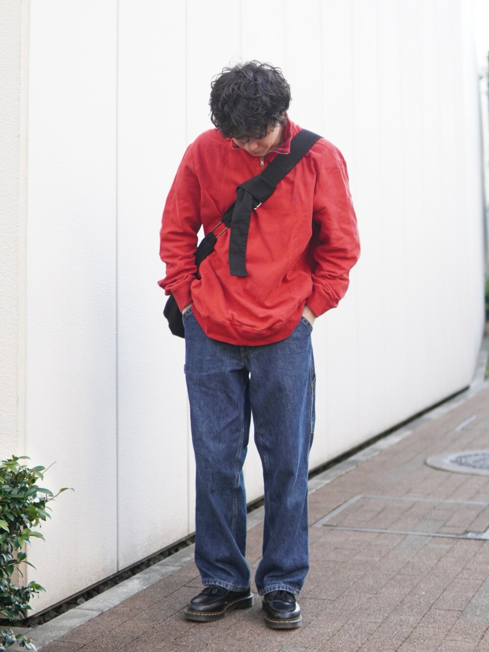 ブルー系のデニムパンツ、ブラック系のローファー、レッド系のスウェットを着用したメンズの春コーディネートの1枚目の写真