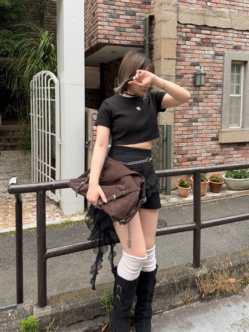 ブラウン系のショルダーバッグ、ブラック系のスカート、ブラック系のTシャツ/カットソーを着用したレディースの夏コーディネートの1枚目の写真