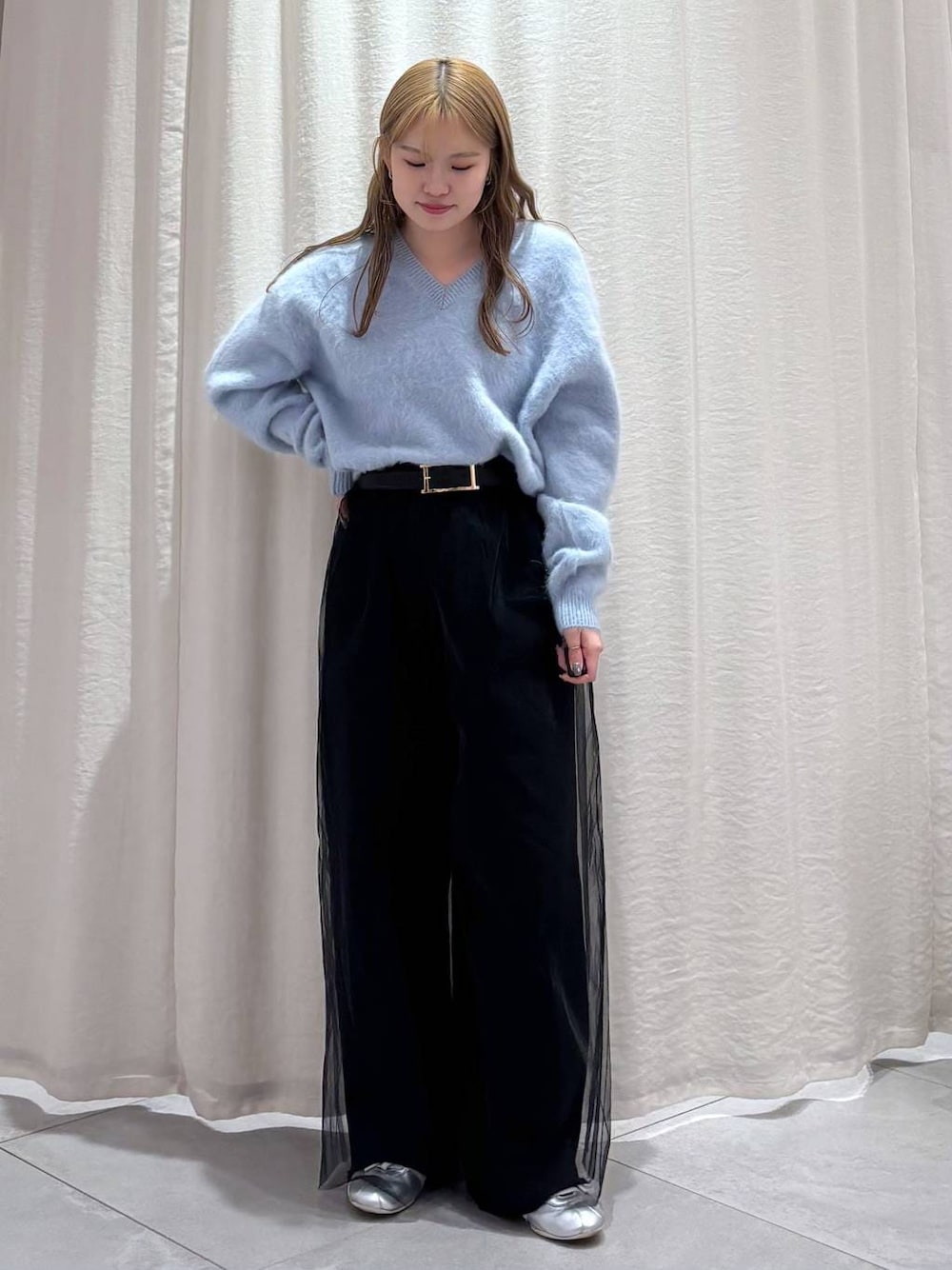 ブルー系のニット/セーター、シルバー系のスニーカー、ブラック系のその他パンツを着用したレディースの秋コーディネートの1枚目の写真