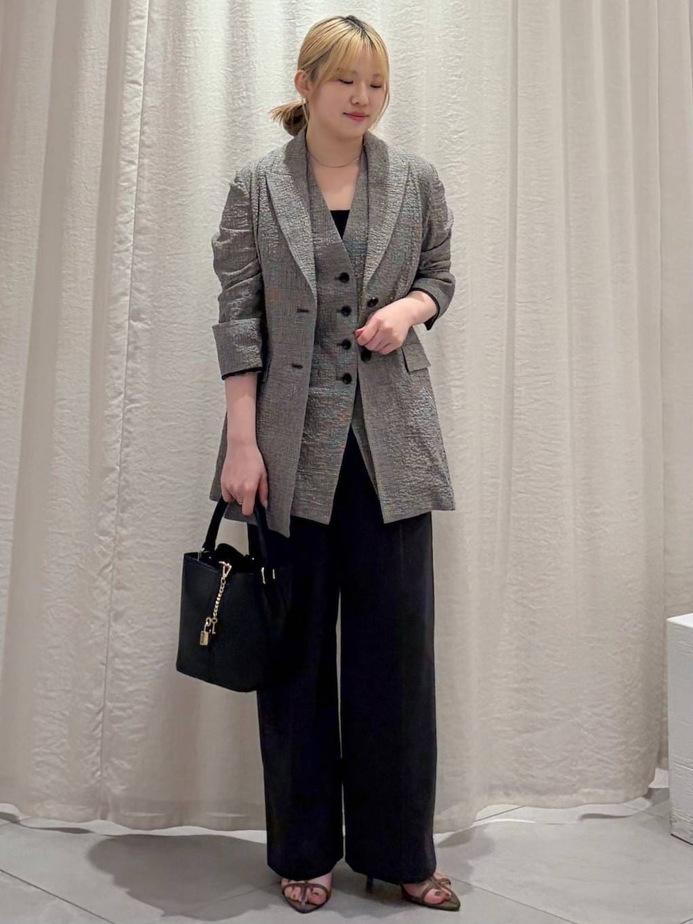 ベージュ系のその他パンツ、ベージュ系のサンダル、ブラック系のショルダーバッグを着用したレディースの春コーディネートの1枚目の写真