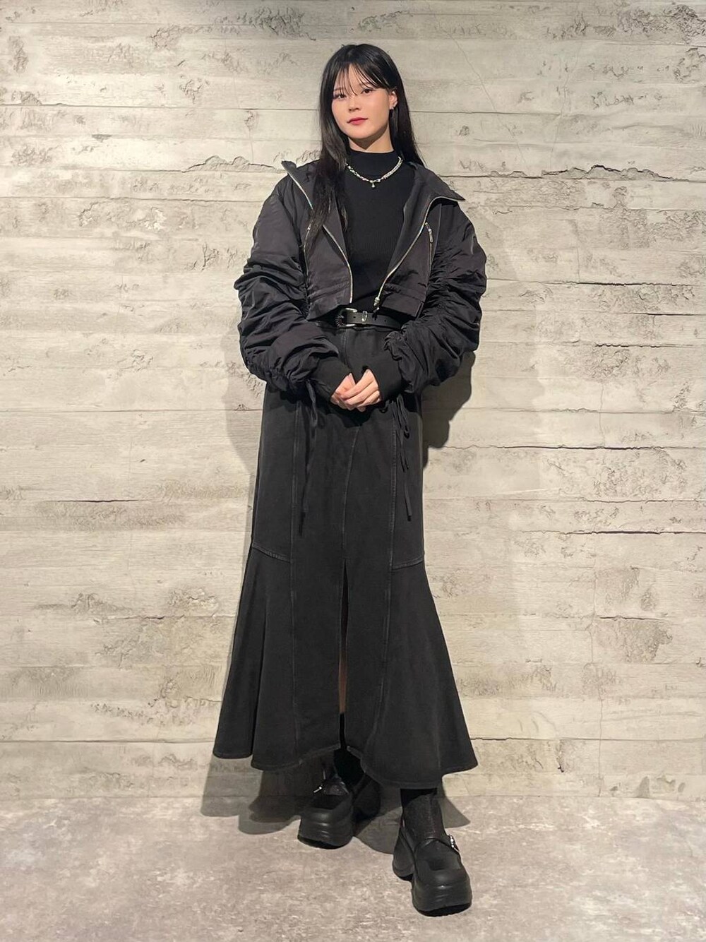 ブラック系のブーツ、ブラック系のニット/セーター、ブラック系のスカートを着用したレディースの秋コーディネートの1枚目の写真