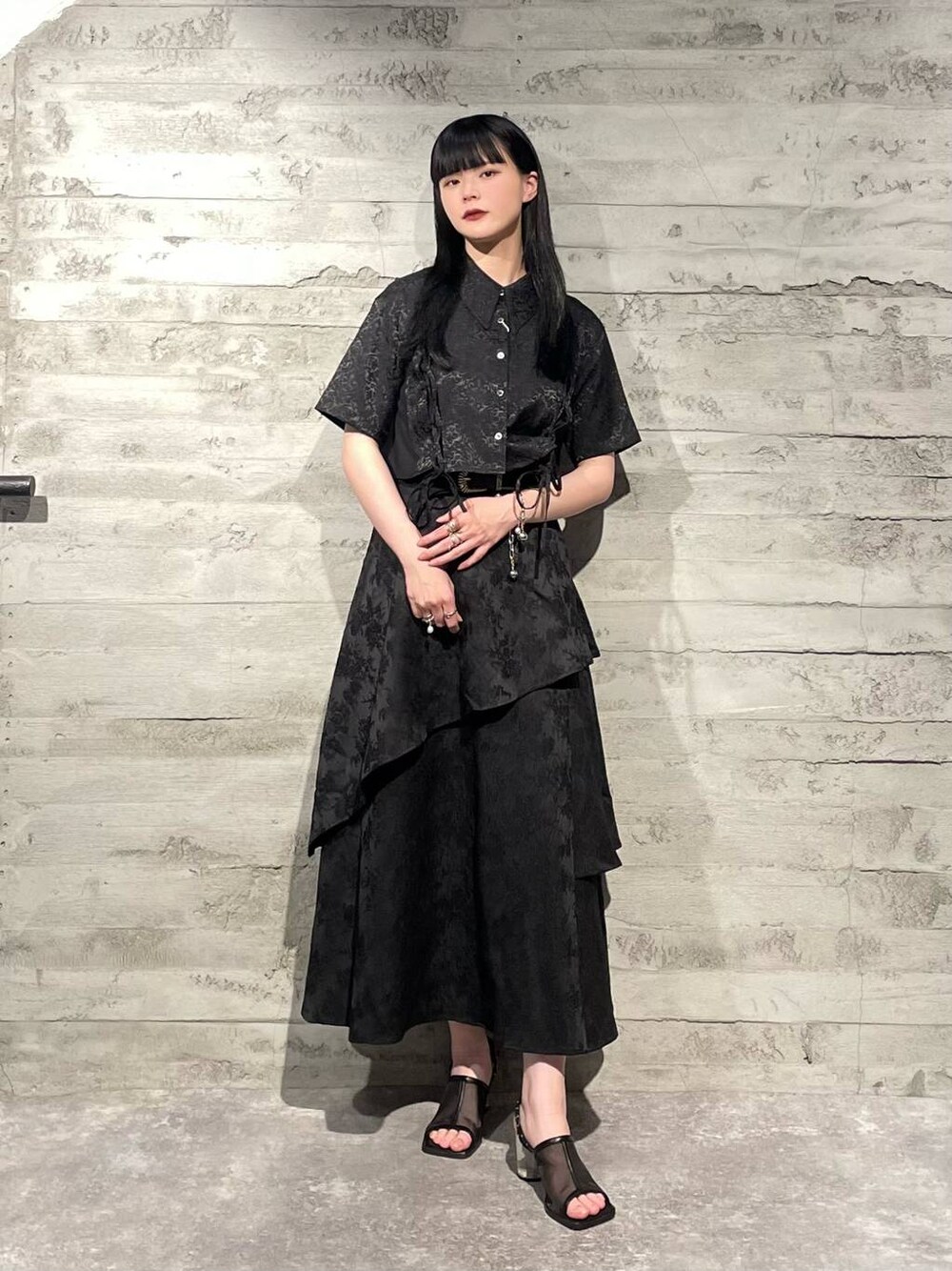 ブラック系のサンダル、ブラック系のシャツ/ブラウス、ブラック系のスカートを着用したレディースの夏コーディネートの1枚目の写真