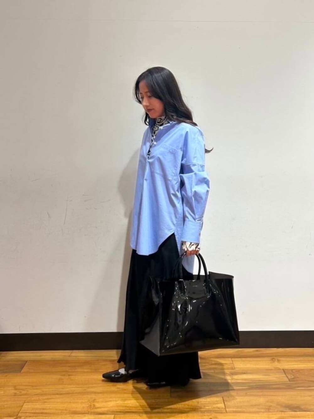 ブラック系のパンプス、ブラック系のスカート、ブラック系のTシャツ/カットソーを着用したレディースの冬コーディネートの1枚目の写真