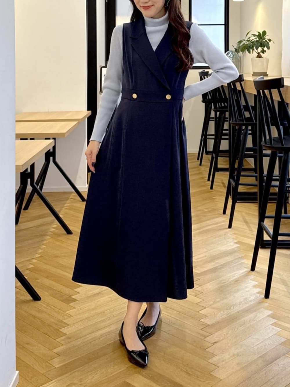 ブルー系のニット/セーター、ブルー系のジャンパースカートを着用したレディースの秋コーディネートの1枚目の写真