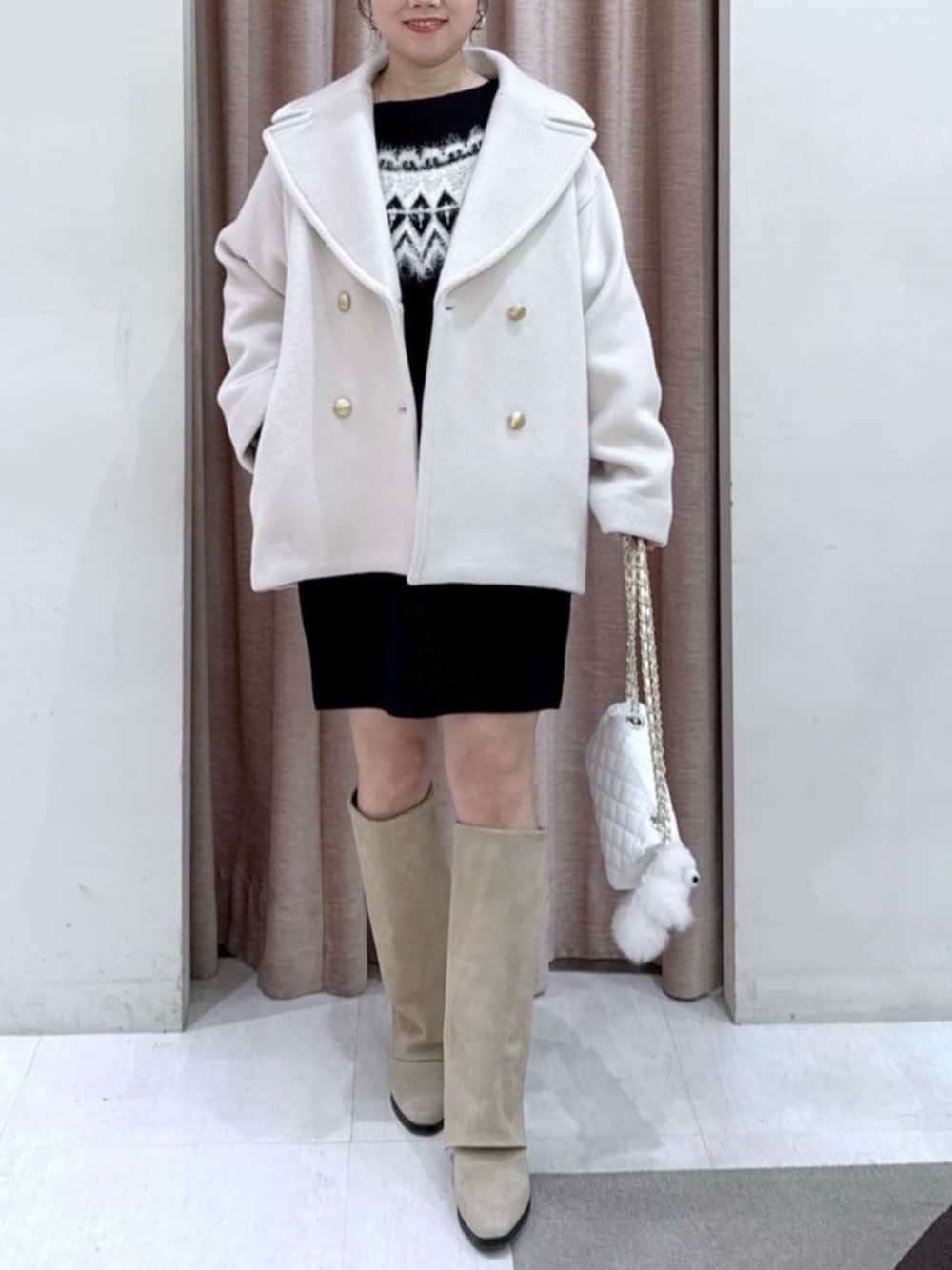 ホワイト系のトートバッグ、ブラック系のワンピース、ホワイト系のピーコートを着用したレディースの冬コーディネートの1枚目の写真