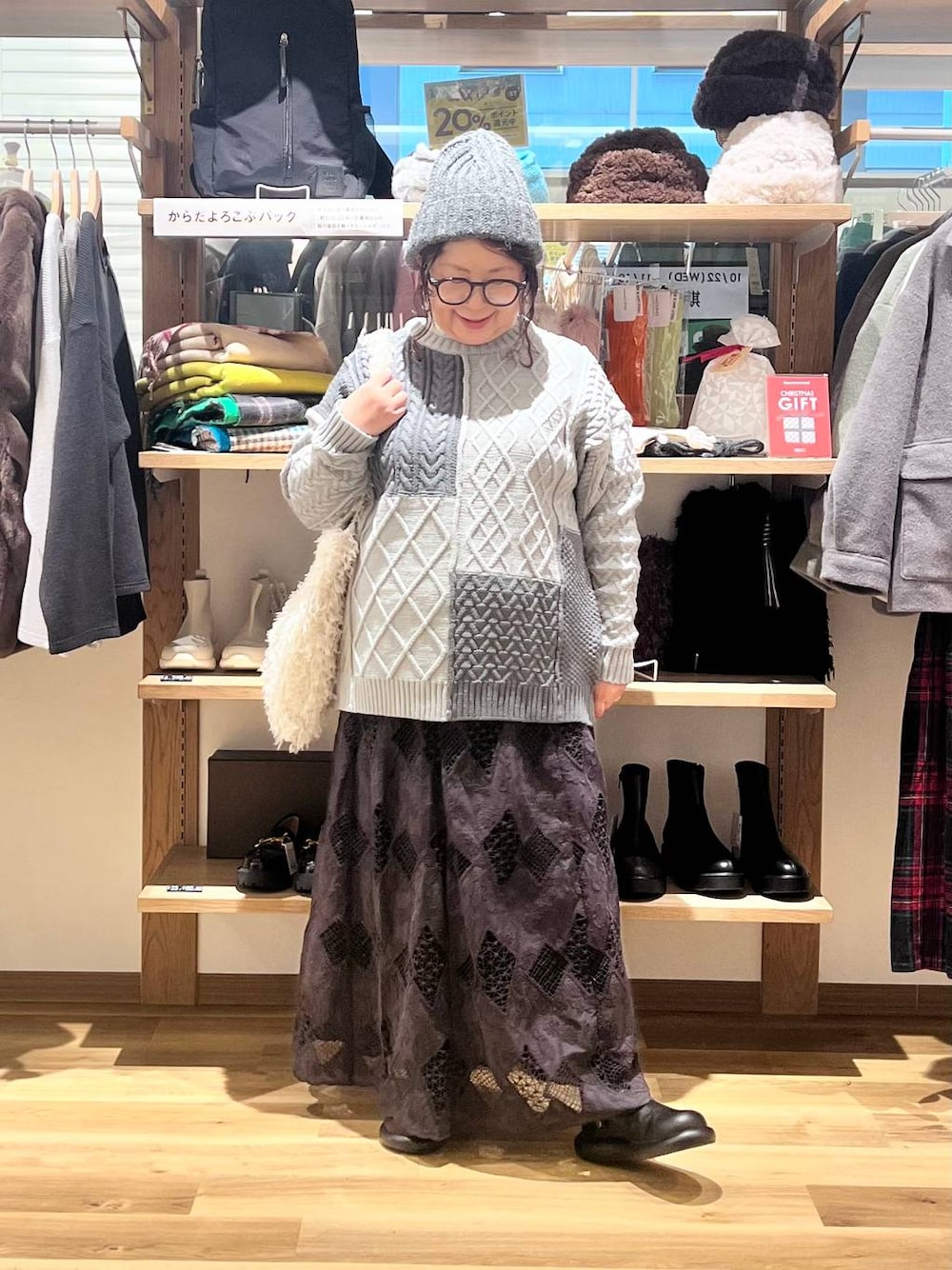 ベージュ系のトートバッグ、その他のニット/セーター、ブラック系のサンダルを着用したレディースの秋コーディネートの1枚目の写真